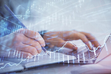 Double exposure of businesswoman hands typing on computer and forex chart hologram drawing. Financial analysis concept.