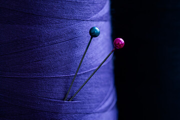 Close up view of sewing pins in blue cloth