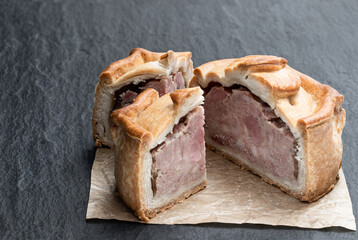 Seasoned cured pork and ham pie on stone background