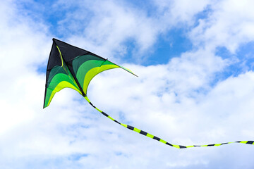 Colorful kite flying through air on sky background