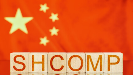 shcomp. wooden blocks with shcomp (Shanghai Composite Index) written on the background of the flag of china