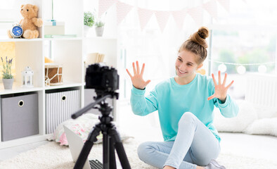 Blogger girl shooting vlog on camera in light room
