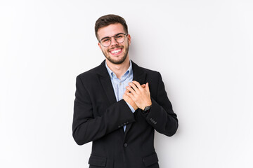 Young caucasian business man posing in a white background isolated Young caucasian business man laughing keeping hands on heart, concept of happiness.