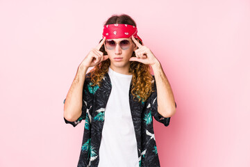 Young hippie caucasian man isolated focused on a task, keeping forefingers pointing head.