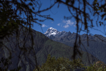 Beautiful landscape at the top of the Andean mountains as the protagonist of a snowy background framed by tree branches