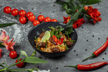 Fried rice with beef and vegetables on a gray textured background