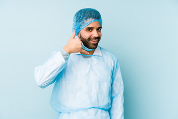 Young surgeon latin man isolated Young dshowing a mobile phone call gesture with fingers.