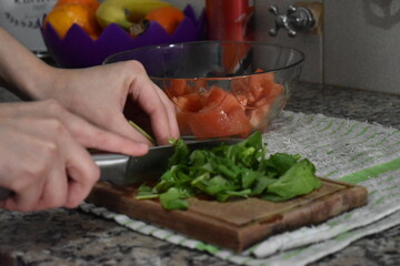 woman cutting spinach and making salad