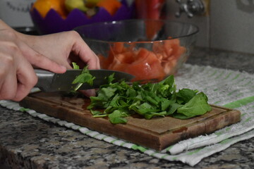 woman cutting spinach and making salad