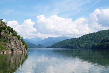 Fototapeta na wymiar Beautiful lake between hills covered with green forest
