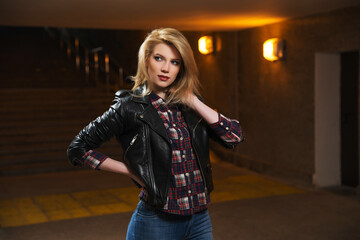 Young fashion blonde woman in black leather jacket