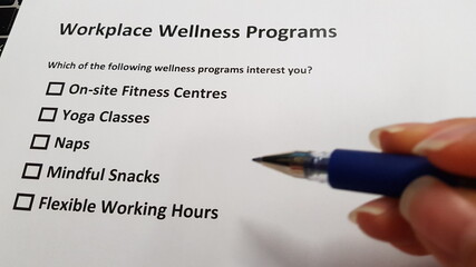 hand and pen filling up workplace wellness program form