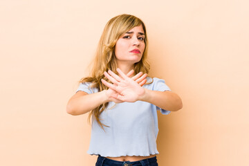 Young blonde caucasian woman doing a denial gesture