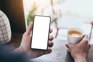 cell phone mockup blank white screen.man hand holding texting using mobile on desk at coffee shop.background empty space for advertise.work people contact marketing business,technology