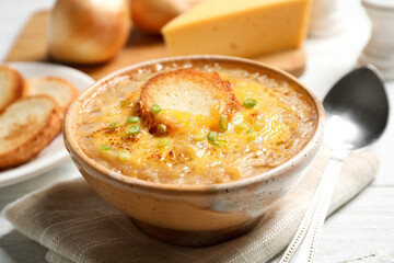 Tasty homemade french onion soup served on white table, closeup