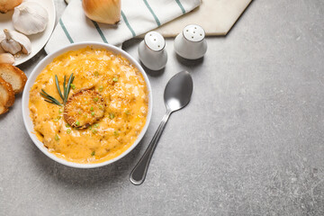 Tasty homemade French onion soup on grey table, flat lay. Space for text