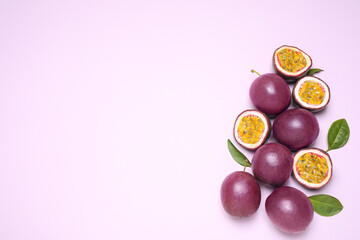 Fresh ripe passion fruits (maracuyas) with leaves on light pink background, flat lay. Space for text