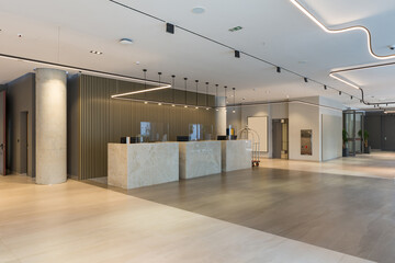 Interior of a hotel lobby with reception desks with transparent covid plexiglass lexan clear sneeze...