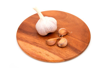 Garlic Cloves and Garlic Bulb on a wooden chopping Board