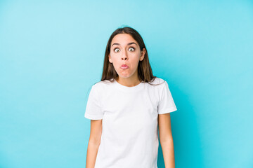 Young caucasian woman  isolated shrugs shoulders and open eyes confused.