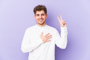 Young blond curly hair caucasian man isolated taking an oath, putting hand on chest.