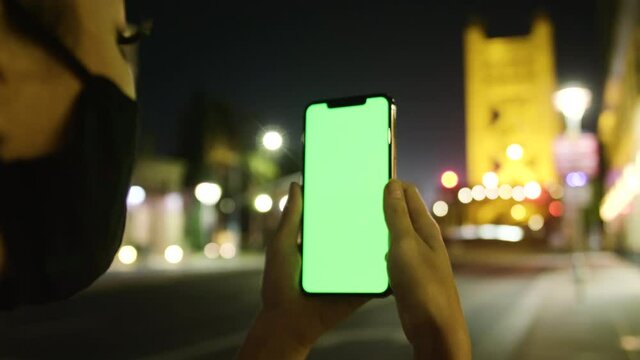 Woman uses iphone at the tower bridge in sacramento