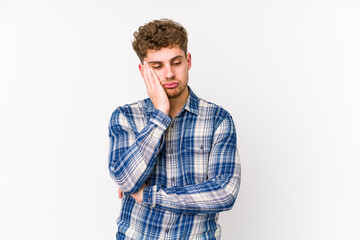 Young blond curly hair caucasian man isolated who is bored, fatigued and need a relax day.