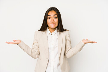 Young woman isolated on a white background confused and doubtful shrugging shoulders to hold a copy space.