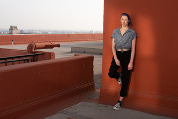 Tall young urban female enjoying the sunshine on a city rooftop overlooking Downtown Los Angeles.