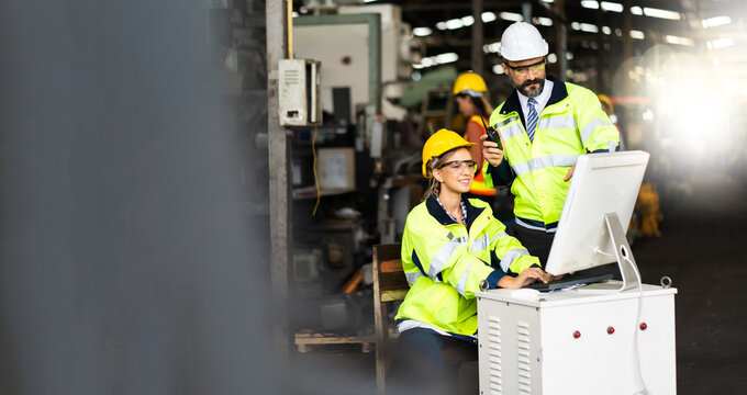 Engineer Man And Woman Worker Working On Personal Computer In Heavy Industry Manufacturing Facility. Professional Engineering Team.