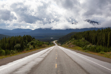 Beautiful View of a scenic road in the Northern Rockies during a sunny and cloudy morning. Taken in British Columbia, Canada. Nature Background