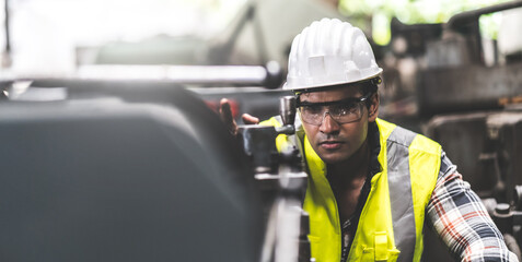 Man at work. Mechanical Engineer  man in Hard Hat Wearing Safety Jacket working in Heavy Industry Manufacturing Facility. Professional Engineer Operating lathe Machinery