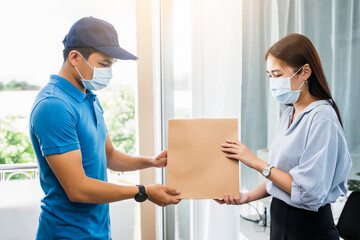 Obraz premium Deliveryman delivering package food order giving to female customer at home wearing face mask safety coronavirus covid-19 infection customer delivery service logistics ordering mail posting business