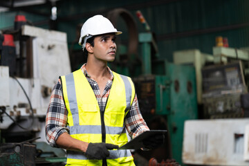 Man at work. Mechanical Engineer  man in Hard Hat Wearing Safety Jacket working in Heavy Industry Manufacturing Facility. Professional Engineer Operating lathe Machinery