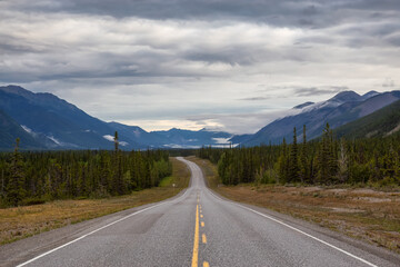 Fototapeta premium Beautiful View of a scenic road in the Northern Rockies during a sunny and cloudy morning sunrise. Taken in British Columbia, Canada. Nature Background