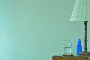 mineral water. put a mahogany shade lamp on a mahogany table. This expensive antique furniture is made in England. blurred background with copy space.