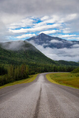 Naklejka premium Beautiful View of a scenic road in the Northern Rockies during a sunny and cloudy morning sunrise. Taken in British Columbia, Canada. Nature Background