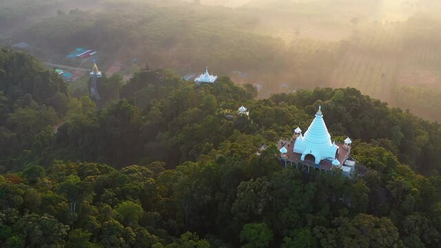 4K drone footage of Buddhism temple Thamma Park padoga on hill at sunrise in Ban Khao Na Nai village in Phanom, Surat Thani, Thailand