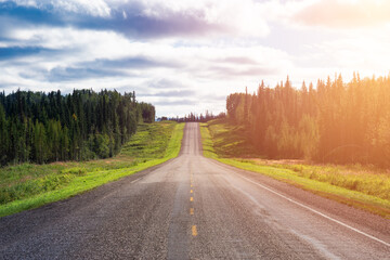 Fototapeta premium Beautiful View of a scenic road in the Northern Rockies during a sunny and cloudy day. Taken in British Columbia, Canada. Nature Background Panorama
