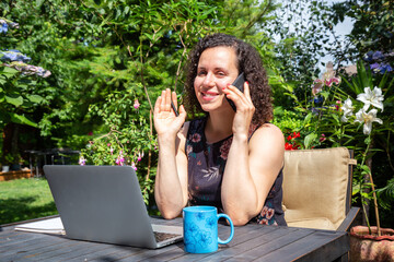 Young Caucasian Woman Working on a Laptop from Home in a Garden. Taken in Surrey, Vancouver, British Columbia, Canada.