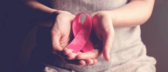 woman holding pink ribbon, breast cancer awareness, October pink concept - obrazy, fototapety, plakaty