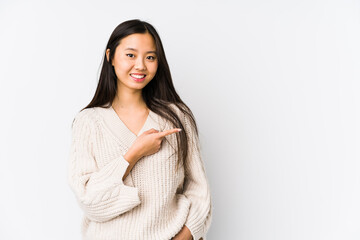 Young chinese woman isolated smiling and pointing aside, showing something at blank space.