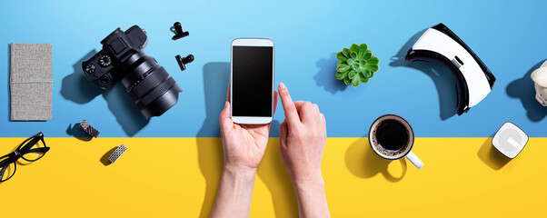 Person using a smartphone with a VR and a SLR camera