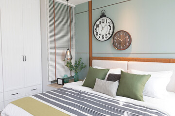 Modern green and brown bedroom with striped pattern. large wall clock on wall.