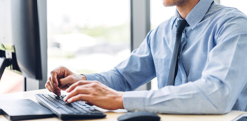 Businessman relaxing looking at technology of desktop computer monitor while sitting on chair.Young creative coworkers business people working and typing on keyboard at office