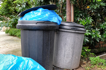 Trash bins outside residential homes overfilled with garbage as it waits for the day's rubbish...