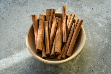 Cinnamon sticks in a bowl on a concrete table