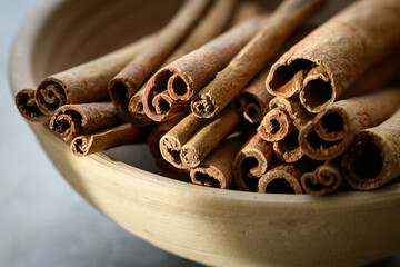 Cinnamon sticks in a bowl on a concrete table