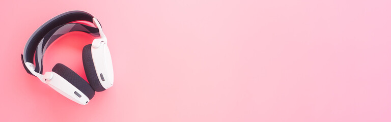 White music headphones on pink background. web banner size.
