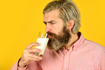 Fototapeta premium Pasteurized milk. Emotional bearded man hold glass of milk. Vegan milk concept. Vegan milks made from wide variety of beans nut, seeds and grains. Healthy food. Drink protein cocktail. Lactose free